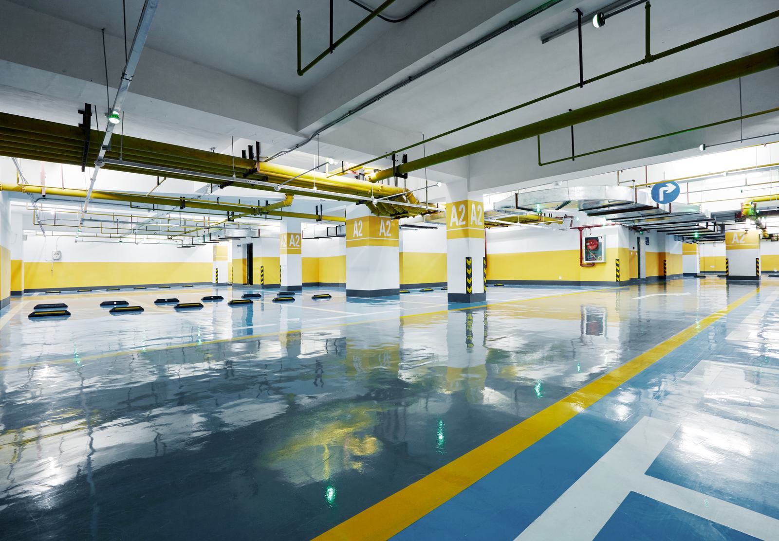 Gray coated parking structure floor with bright yellow safety markings